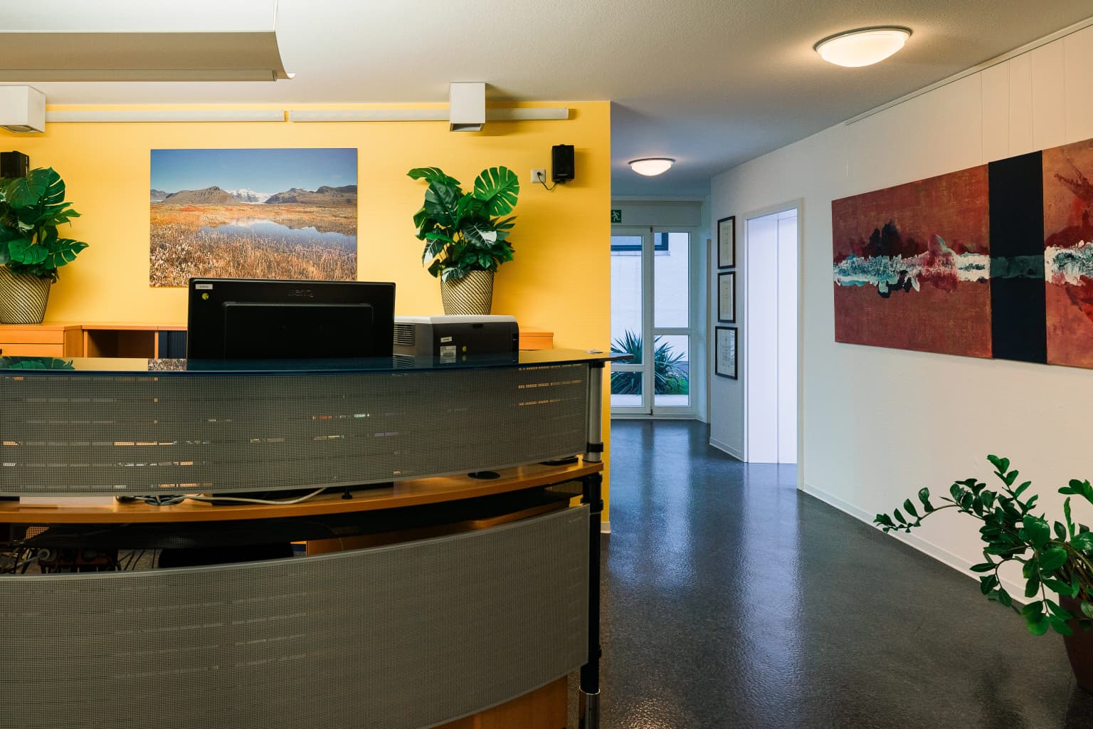 Zahnarztpraxis Dr. Jan Ploke: Behandlungsraum mit Behandlungsstuhl, Schrank und Schreibtisch